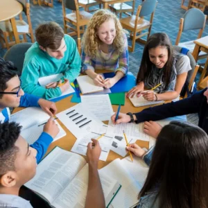 Studying students gathered around a table working on their homework.