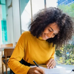 Woman writing at a table.