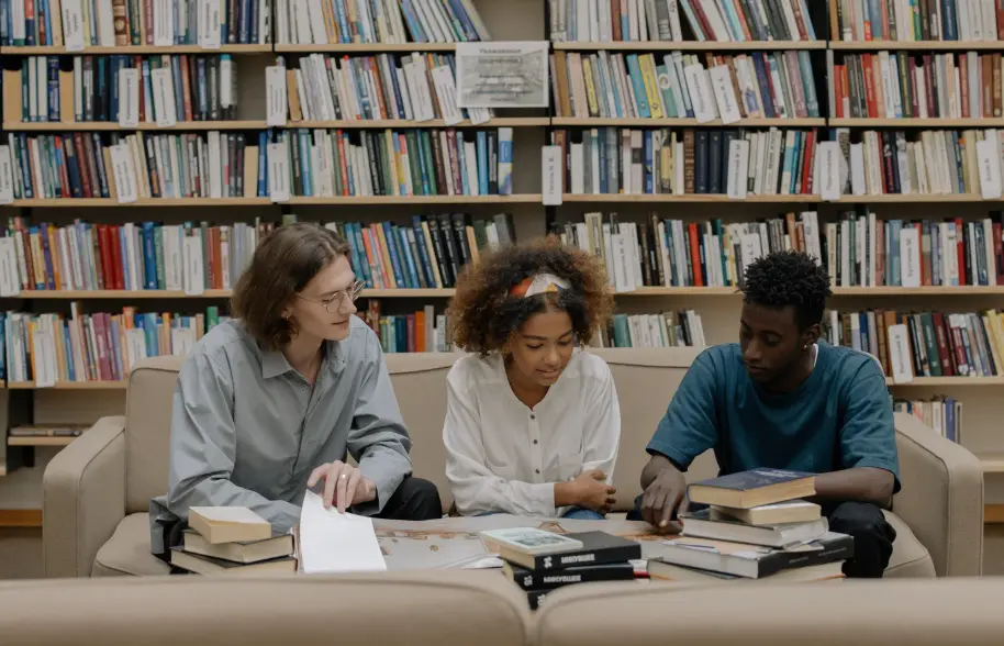 Students studying on a couch in the library.