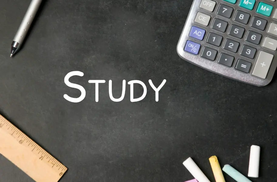 Blackboard with the word Study written in white, surrounded by a pen, ruler, calculator, and colorful chalk.